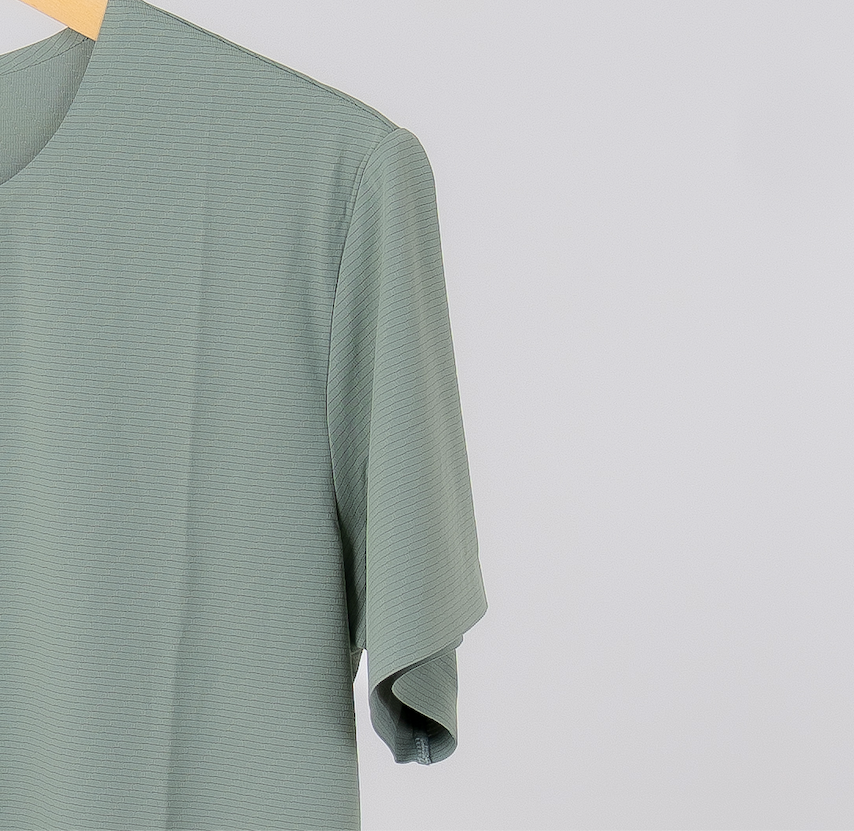 A closeup of the gennady a high performance workout shirt that shows the lightweight and breathable fabric in the color celadon. Designed for consistent support.