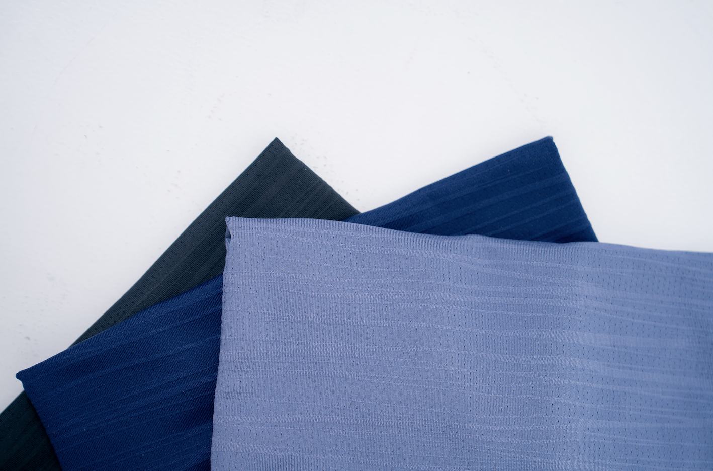 Three folded t-shirts named the Omaha, made out of high performance lightweight fabric designed to be versatile, for work, travel, training and every day life. 