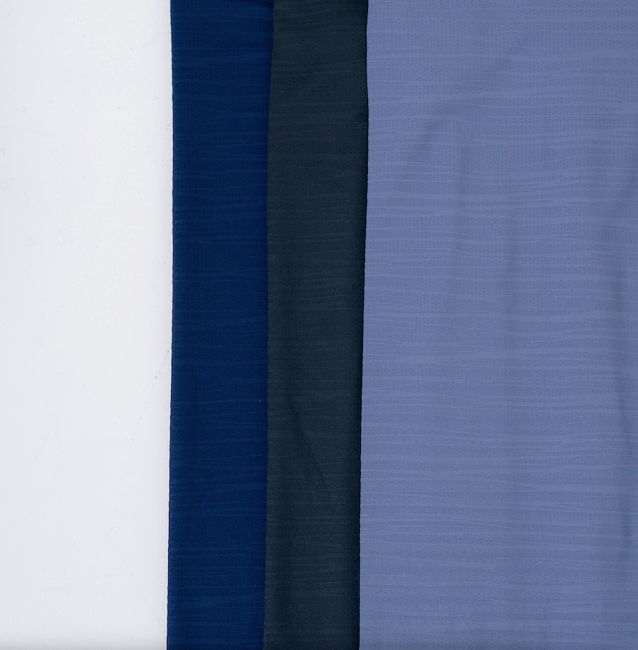 A close up of the fabrics colored navy, charcoal and cool blue, used in the Omaha, a A versatile performance t-shirt built for work, travel, training and everyday life. Designed for men who adjust to every challenge.