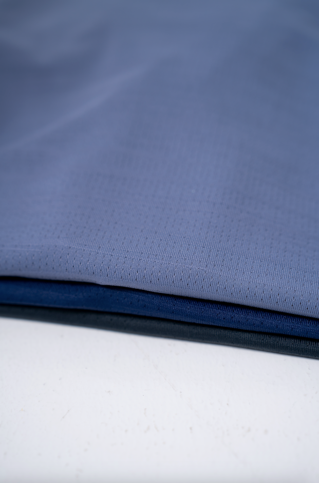 A close-up of the high performance fabric, colored cool blue, navy and charcoal that is used in the Omaha, an all-round performance t-shirt designed for the man who adapts to every enviroment.
