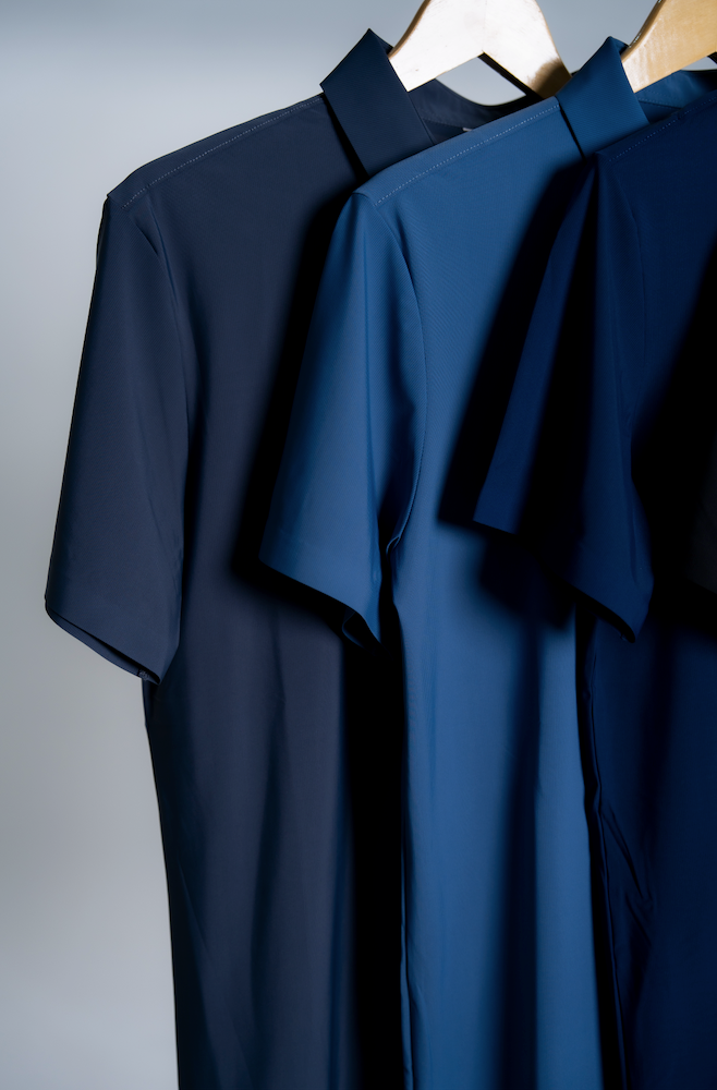 Close up of three short-sleeve mens polo shirts in navy, cool blue and slate grey made out of high performance stretchy fabric. 